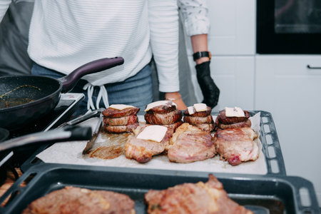 cooking steaks in a pan. cooking beef at the culinary master class. the hands of the chef in black...
