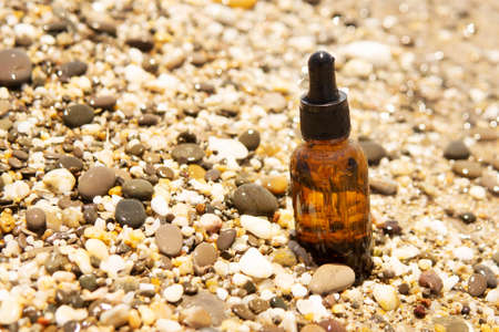 Cosmetic serum in a glass bottle with a pipette on stonesの写真素材