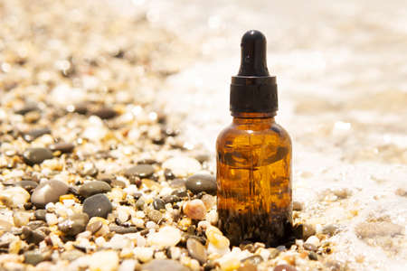 Cosmetic serum in a glass bottle with a pipette on stonesの写真素材