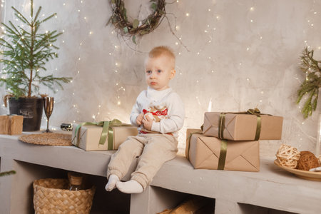 A little boy is playing on Christmas Eve in a beautiful house decorated for the New Year holidaysの写真素材