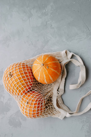 Mesh shopping bag with vegetables. Autumn pumpkin harvestの写真素材