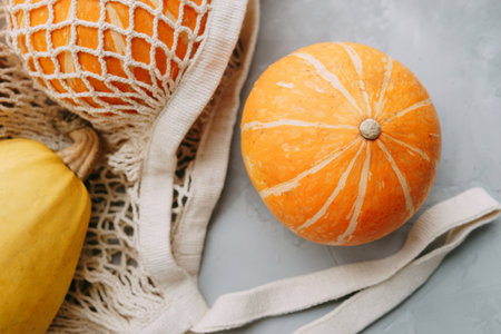 Mesh shopping bag with vegetables. Autumn pumpkin harvestの写真素材