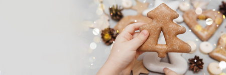 Childrens hands hold a gingerbread in the shape of a Christmas tree. The concept of Christmas...