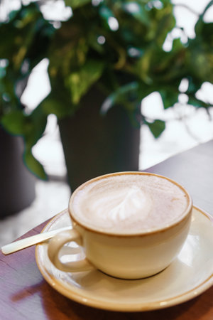 Coffee cup with a heart pattern in a blue cup on a wooden backgroundの写真素材