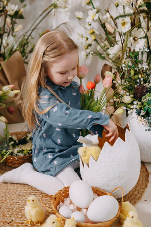 Two girls in a beautiful Easter photo zone with flowers, eggs, chickens and Easter bunnies. Happy...