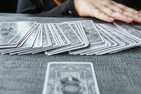TVER, RUSSIA - FEBRUARY 11, 2023. Tarot cards, Tarot card divination, esoteric background. A woman makes a layout on the cards at the table. Divination, predictions on tarot cards.のeditorial素材