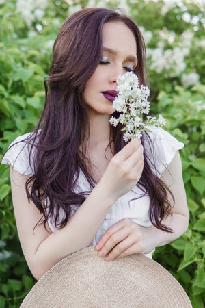 A fashionable girl with dark hair, a spring portrait in lilac tones in summer. Bright professional makeup.の写真素材