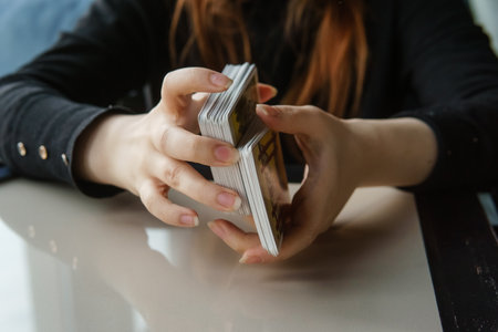 Tarot cards, Tarot card divination, esoteric background. A woman makes a layout on the cards at the table. Divination, predictions on tarot cards.の写真素材