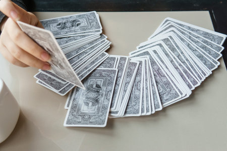Tarot cards, Tarot card divination, esoteric background. A woman makes a layout on the cards at the...