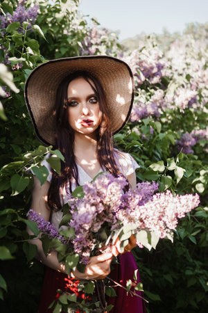 A fashionable girl with dark hair, a spring portrait in lilac tones in summer. Bright professional makeup.の写真素材