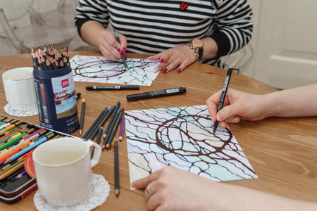 TVER, RUSSIA - FEBRUARY 25, 2023: Woman draws neurographics at table at a psychological session, neurographic pencil drawing to remove restrictions, art therapyのeditorial素材