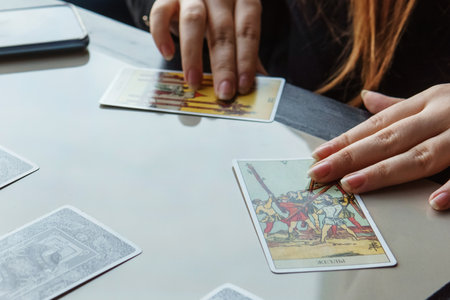 TVER, RUSSIA - FEBRUARY 11, 2023. Tarot cards, Tarot card divination, esoteric background. A woman makes a layout on the cards at the table. Divination, predictions on tarot cards.のeditorial素材