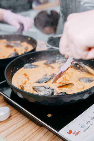 Cooking black pasta with seafood in a cooking class. Italian pasta with seafood. Mussels, squid, shrimp. Homemade food.の写真素材