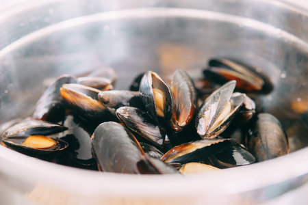 Raw mussels in a metal container. Cooking master class on food preparation. Home cooking, cooking at home. Close-up.の写真素材