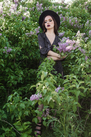 A fashionable girl with dark hair, a spring portrait in lilac tones in summer. Bright professional makeup.の写真素材