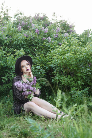 A fashionable girl with dark hair, a spring portrait in lilac tones in summer. Bright professional makeup.の写真素材