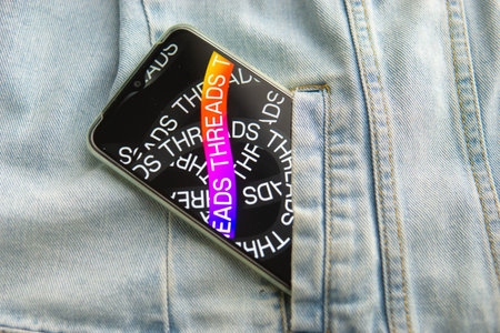 Tver, Russia - July 15, 2023, the threads logo on the smartphone screen lying on the jeans. The...