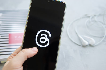 Tver, Russia - July 15, 2023, threads logo on the smartphone screen, on a gray background. The threads icon. The logo of the current application. Threads social network.のeditorial素材