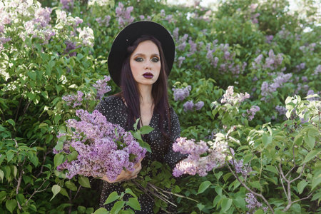 A fashionable girl with dark hair, a spring portrait in lilac tones in summer. Bright professional...