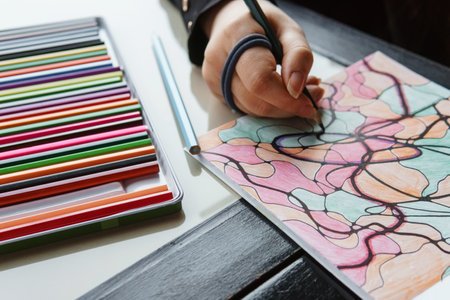 TVER, RUSSIA - FEBRUARY 11, 2023: a young woman draws neurography at a table at a psychological session, a neurographic resunok with a pencil to remove oranicheniy, art therapyのeditorial素材