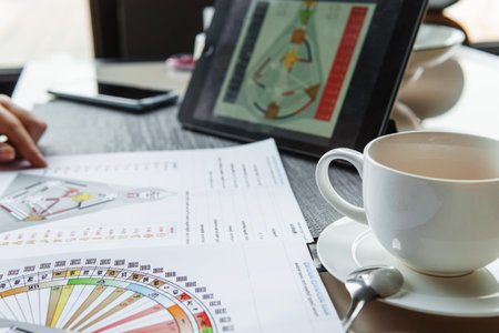 TVER, RUSSIA - FEBRUARY 12, 2023: A beautiful girl in a white nightgown at home, surrounded by spring flowers on a large bed. A room decorated with bouquets of peoniesのeditorial素材