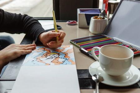 TVER, RUSSIA - FEBRUARY 11, 2023: a young woman draws neurography at a table at a psychological session, a neurographic resunok with a pencil to remove oranicheniy, art therapyのeditorial素材