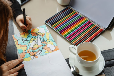TVER, RUSSIA - FEBRUARY 11, 2023: a young woman draws neurography at a table at a psychological session, a neurographic resunok with a pencil to remove oranicheniy, art therapyのeditorial素材