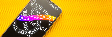 Tver, Russia - July 15, 2023, threads logo on the smartphone screen, on a yellow background. The threads icon. The logo of the current application. Threads social network.のeditorial素材