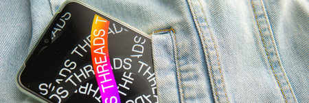 Tver, Russia - July 15, 2023, the threads logo on the smartphone screen lying on the jeans. The...