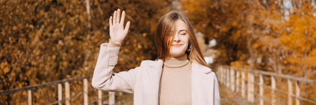 beautiful long-haired woman walks through the autumn streets. Railway, autumn, woman in a coat.の写真素材