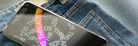 Tver, Russia - July 15, 2023, the threads logo on the smartphone screen lying on the jeans. The...