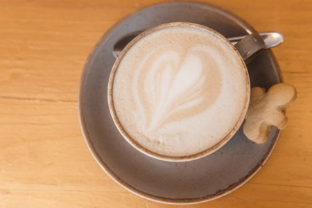 Coffee on a wooden table in a cafe, drawings on coffee.の写真素材