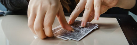 TVER, RUSSIA - FEBRUARY 11, 2023. Tarot cards, Tarot card divination, esoteric background. A woman makes a layout on the cards at the table. Divination, predictions on tarot cards.のeditorial素材