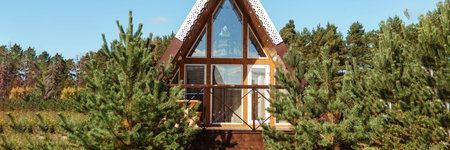 The concept of glamping and renting a chalet for weekend. Wooden house with a veranda in nature...