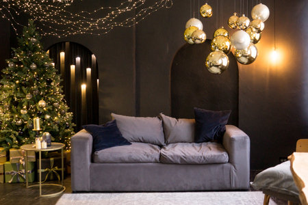 Christmas interior with a beautiful Christmas tree, sofa, light bulbs and dark background.