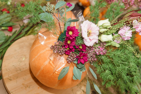 Flower arrangement in a pumpkin, autumn interior decor. Creating handmade autumn decor.の写真素材