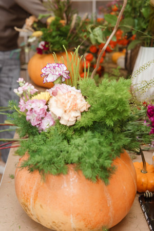 Flower arrangement in a pumpkin, autumn interior decor. Creating handmade autumn decor.の写真素材