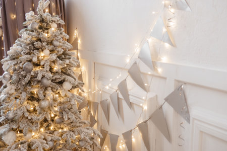 A Christmas tree sprinkled with artificial snow in the New Year's interior. Background for New Year wallpapers and postcards.の写真素材