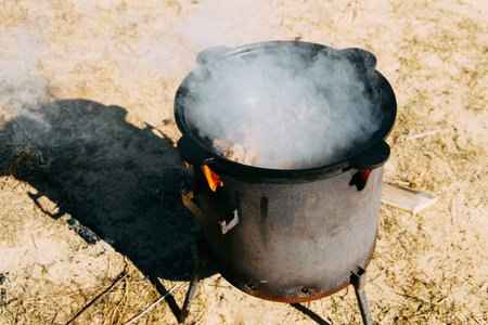 Meat cooking in cauldron outdoor. Plov recipe with meat. Cooking food street. Traditional cuisine and oriental dishの写真素材