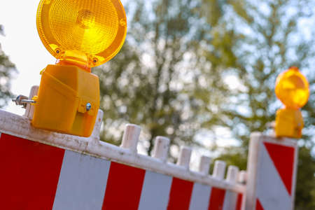 Close-up of red and white barricades with two warning lights, depth of fieldの写真素材