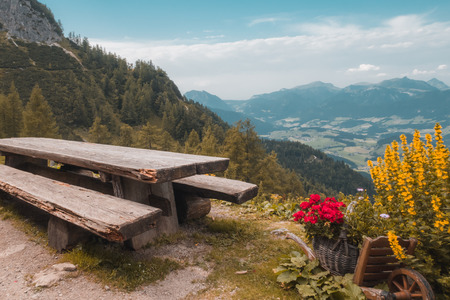 a weathered bench and table for rest with views of mountain and valleyの写真素材