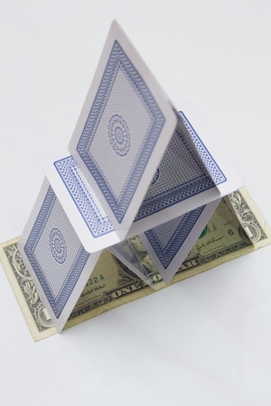 Stack of cards built on a US $1 bill ready to tumbleのeditorial素材
