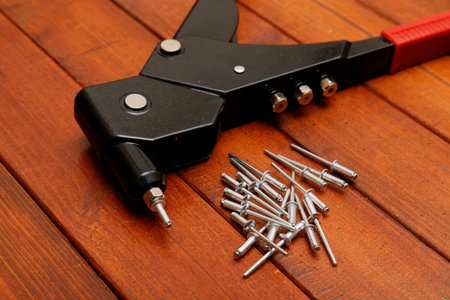 Riverting tool and blind riverts on wood background