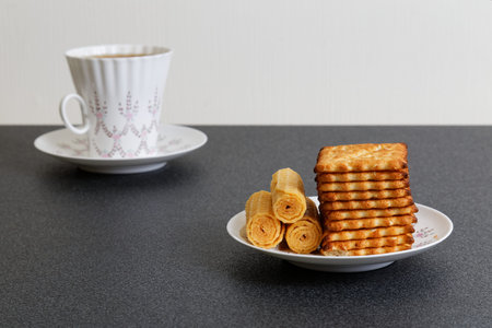 Cookies and defocused cup of tea on the dark table