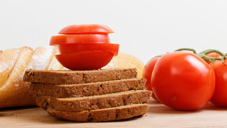 Fresh tomato and bread on the kitchen cutting boardの写真素材