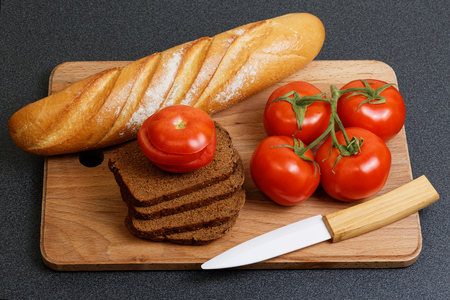 Fresh tomato and bread on the kitchen tableの写真素材