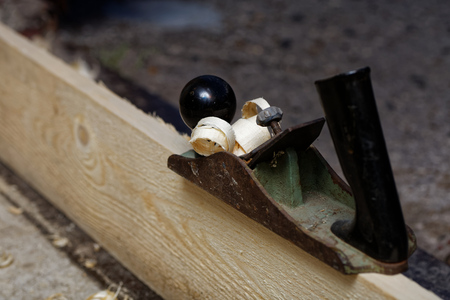Old hand jack-plane and wood chips on the board. Shallow focus.の写真素材