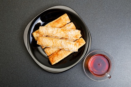 Cup of tea and puff pastry on the dark table. Top view.の写真素材