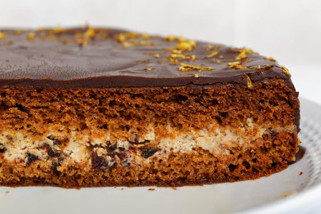 Slice of brownie - chocolate cake with cherry and lemon peel