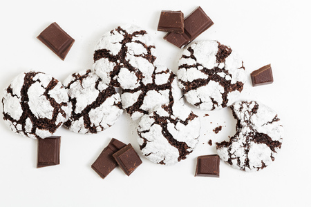 Closeup homemade chocolate crinkles cookies powdered sugar and pieces of chocolate on white background. Top view.の写真素材